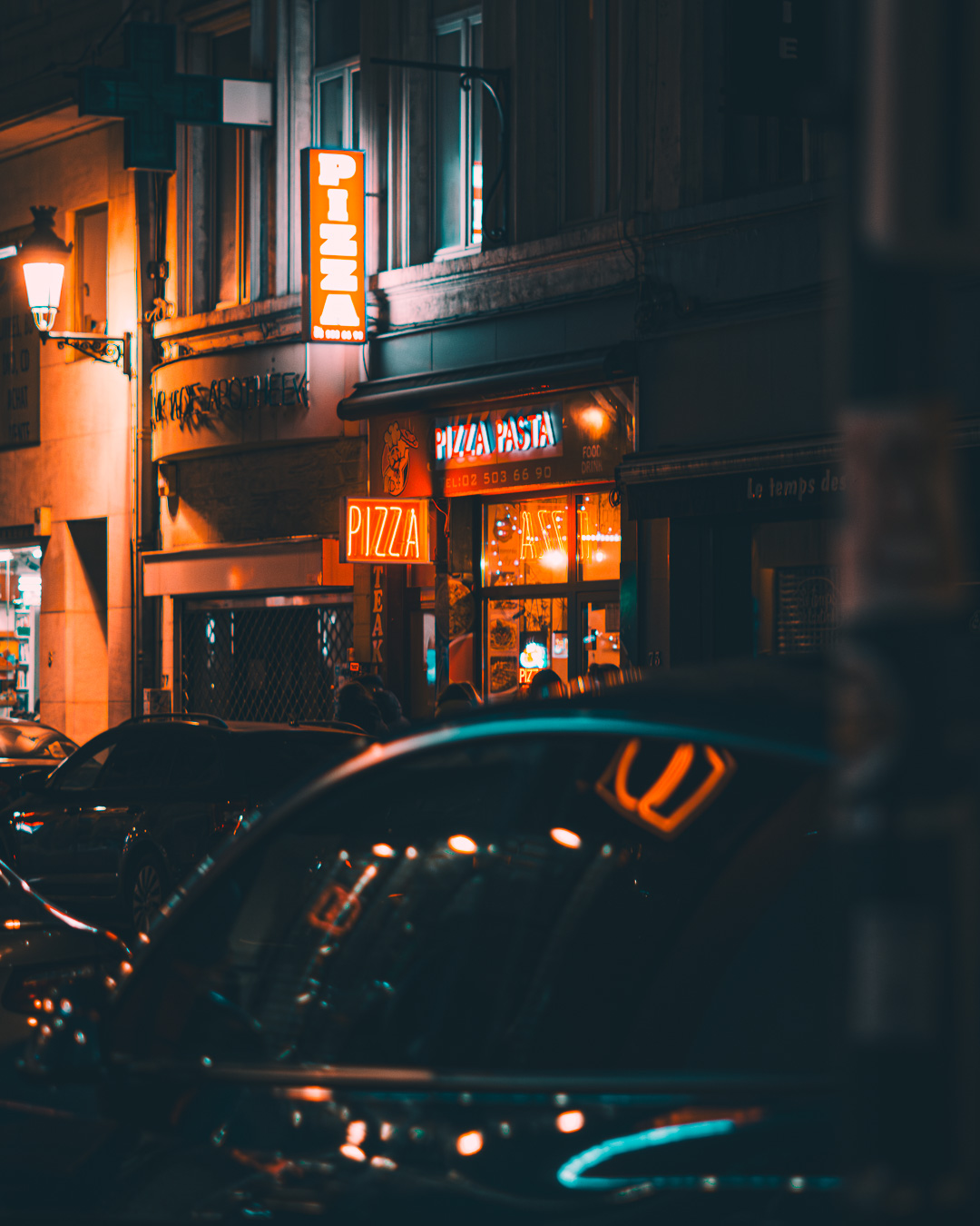 Night photo of an open pizza place with a neon sign