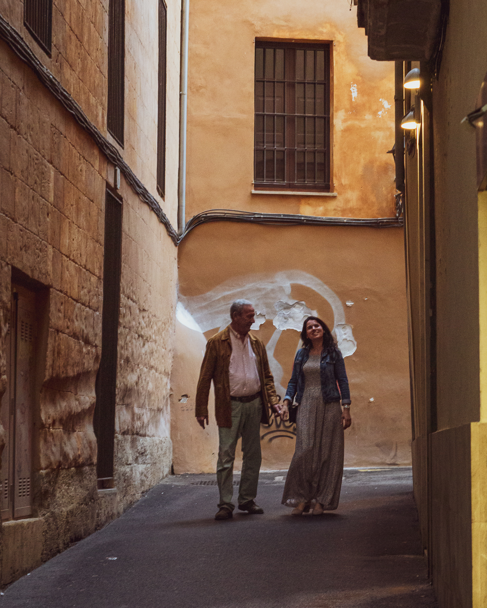 Two people walking down a street in Palma de Mallorca