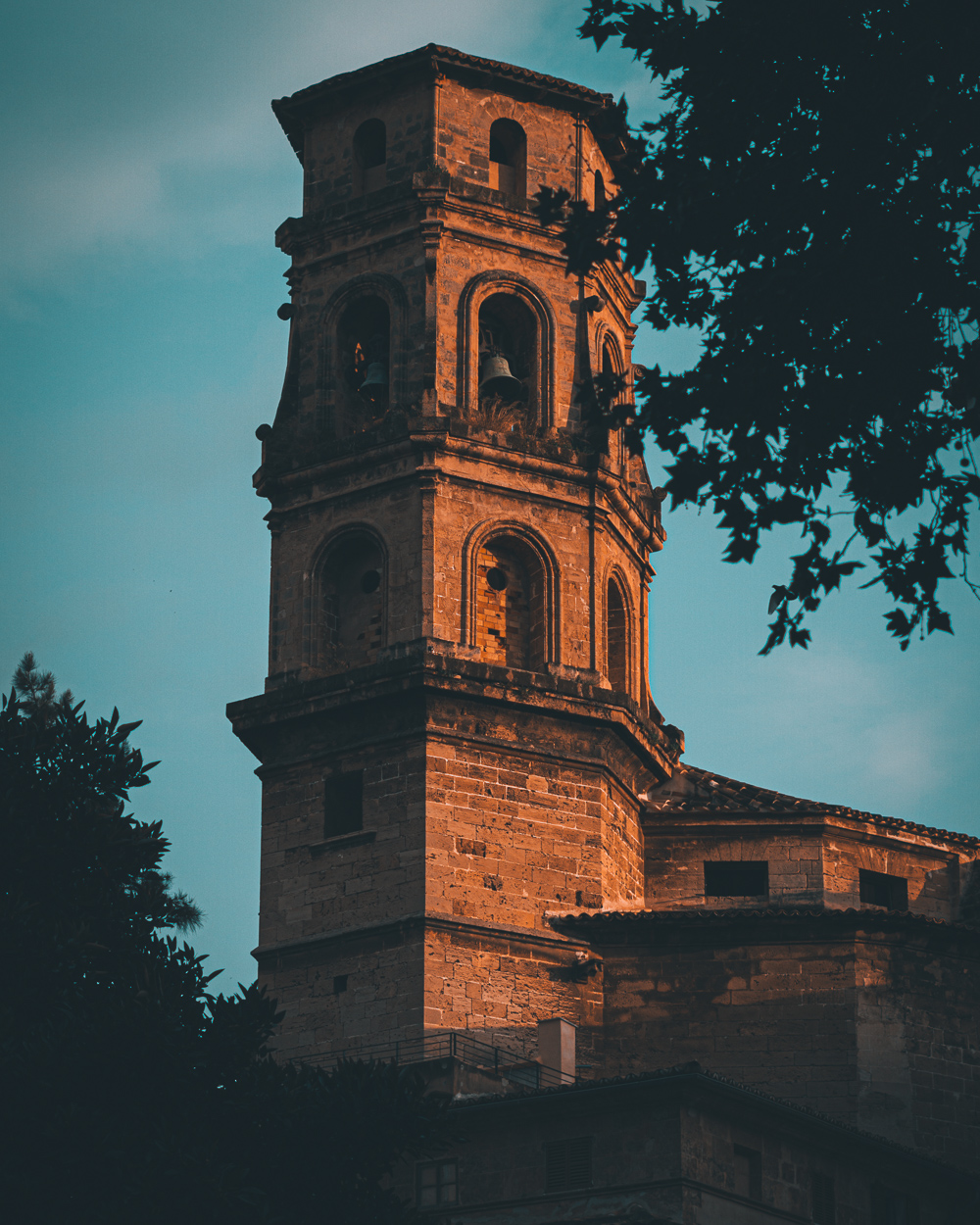 Orange sun illuminating a church tower