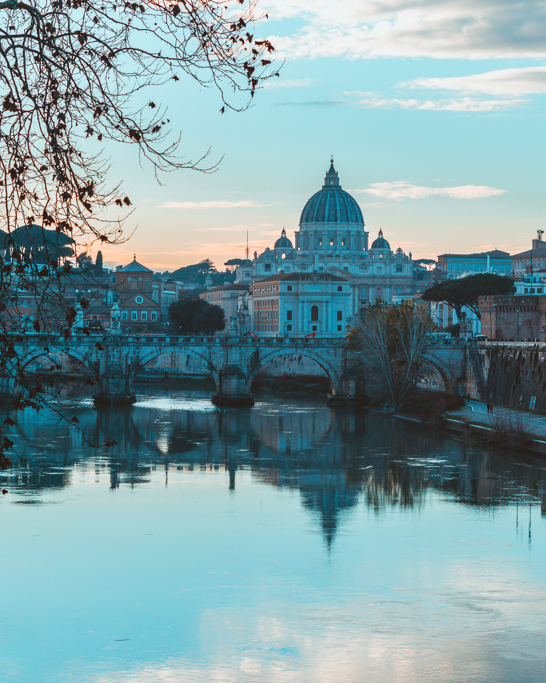 View from a bridge on the Tiber river with St. Peter's Basilica in the background