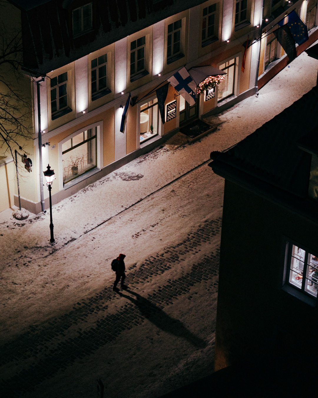 Top down view of old town building at night with a man walking in the street