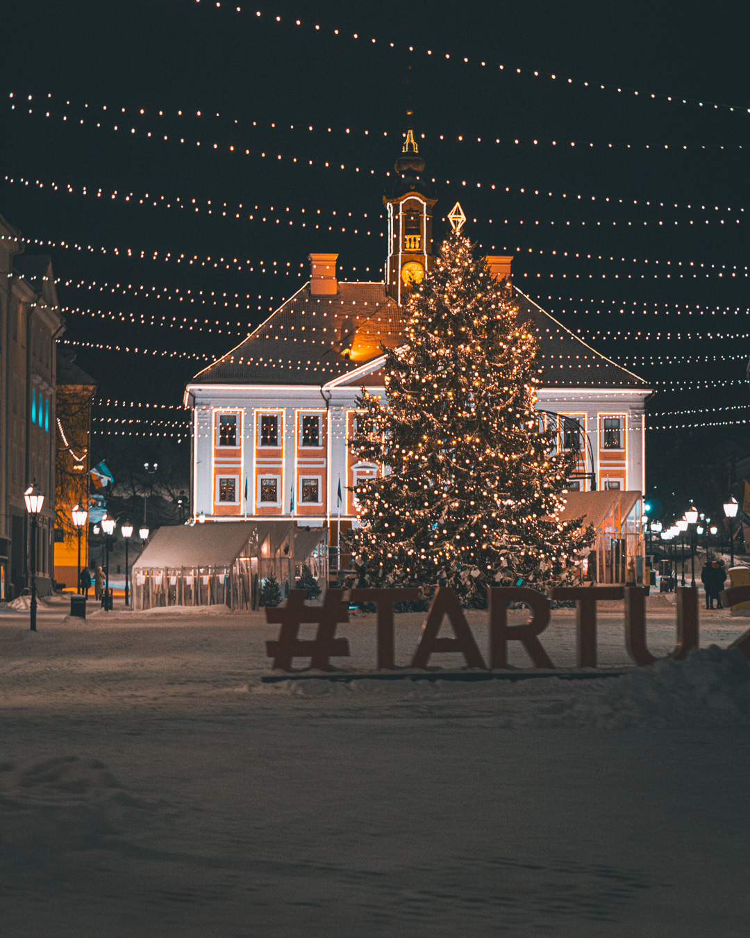 Tartu town hall in the background with a huge snowy christmas tree in the foreground