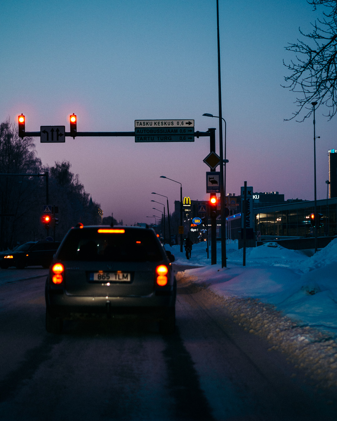 Cars driving on a road with the sunset in the background